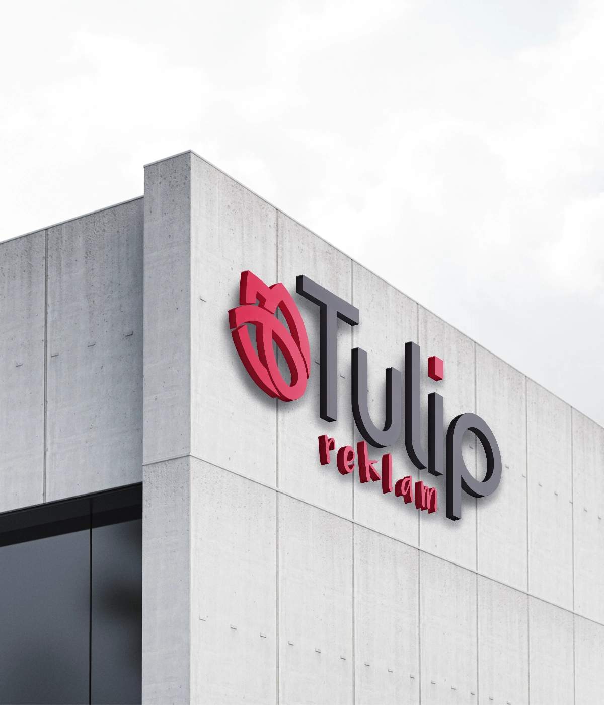 A 3D company logo sign for Tulip Reklam mounted on the corner of a modern concrete building facade against a cloudy sky.
